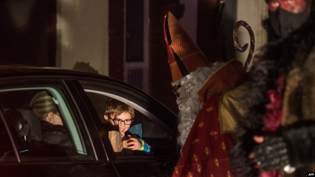 Members of circus company Cirk La Putyka, dressed as Saint Nicholases, entertain people during their drive-through performance, Dec. 5, 2020 in Prague.