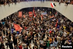 Pendukung ulama Syiah Irak Moqtada al-Sadr memprotes aksi korupsi di dalam gedung parlemen di Baghdad, Irak 27 Juli 2022. (Foto: REUTERS/Thaier Al-Sudani)