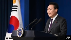 In this photo provided by South Korea Presidential Office, South Korean President Yoon Suk Yeol speaks during the New Year's address to the nation at the presidential office in Seoul, South Korea, Jan. 1, 2023. 