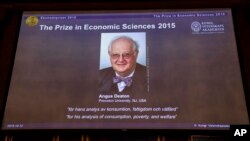 Professor Angus Deaton, winner of the 2015 Sveriges Riksbank Prize in Economic Sciences in Memory of Alfred Nobel, as the Permanent Secretary for the Royal Swedish Academy of Sciences addresses a press conference to announce the winner of the prize, Oct. 