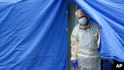 FILE - A medical worker operates a COVID-19 mobile testing tent in the Brooklyn borough of New York, Nov. 11, 2020.