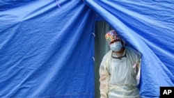 FILE - A medical worker operates a COVID-19 mobile testing tent in the Brooklyn borough of New York, Nov. 11, 2020.