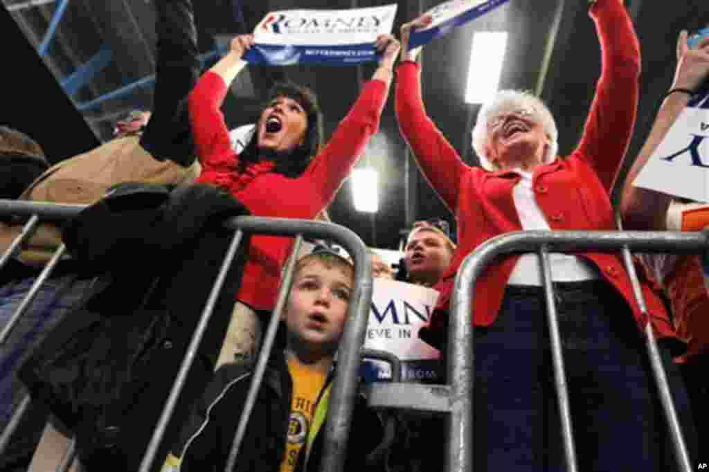 A small boy looks on as supporters cheer as Republican presidential candidate, former Massachusetts Gov. Mitt Romney spoke at a campaign rally at Skyline High School in Idaho Falls, Idaho, Thursday, March 1, 2012. (AP Photo/Gerald Herbert)