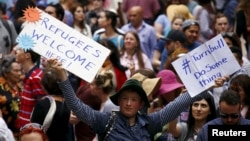 FILE - Demonstrators hold aloft placards during a rally in support of refugees that was part of a national campaign in central Sydney, Australia, Oct. 11, 2015. 