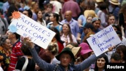 FILE - Demonstrators hold aloft placards during a rally in support of refugees that was part of a national campaign in central Sydney, Australia, Oct. 11, 2015. 