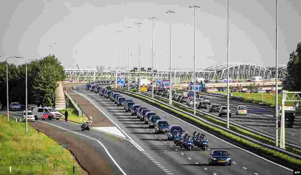 A convoy of hearses carry the remains of the victims of the Malaysia Airlines flight MH17 plane crash from an airbase in Eindhoven to Hilversum, The Netherlands, drives through Waardenburg after a Dutch Air Force C-130 Hercules plane and an Australian Royal Air Force C17 transporting the remains arrived from Kharkiv, Ukraine.