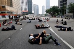 Protesters who camped out overnight take a rest along a main road near the Legislative Council after continuing protest against the unpopular extradition bill in Hong Kong, June 17, 2019.
