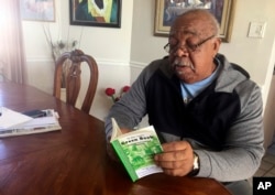 Charles Becknell, Sr., 77, holds a copy of 1954 the edition of "The Negro Motorist Green Book" at his home in Rio Rancho, N.M., Jan. 31, 2019.