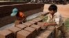 FILE - Cambodian children prepare bricks to dry under the sun at a brick factory in Chheuteal village, Kandal province, some 27 kilometers (17 miles) north of Phnom Penh, Cambodia, May 2, 2011.