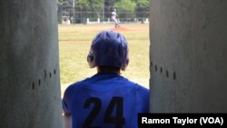 A Cuban baseball player watches action on the field at the 50th Anniversary Stadium in Cuba. 