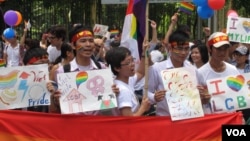 Những người tham gia đạp xe diễu hành vì cộng đồng LGBT vẫy cờ cầu vồng, Hà Nội, 5/8/2012. (Marianne Brown/VOA)