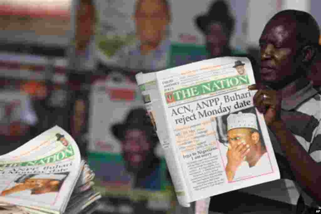 An Unidentified man reads a newspaper with headline Electoral Commission Chairman Attahiru Jega Apologies for elections postponement, published in Lagos, Nigeria, Sunday, April 3, 2011. Nigeria postponed its National Assembly elections Saturday as ballot