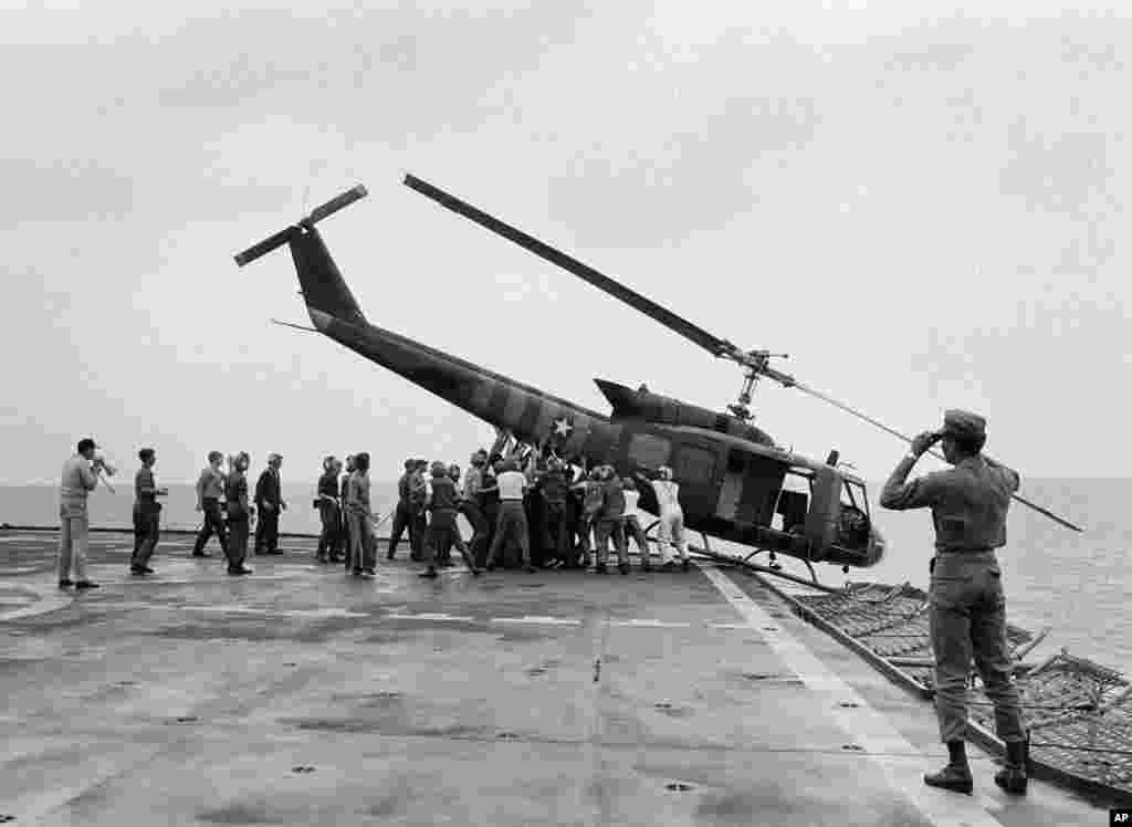 Binh sĩ Hải quân Mỹ trên tàu USS Blue Ridge đẩy một trực thăng xuống biển để dọn chỗ cho những chuyến bay chở người di tản khác từ Sài Gòn tới.
