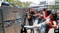 Des manifestants font face aux policiers anti-émeute à Valencia, Venezuela, le 28 mars 2018.