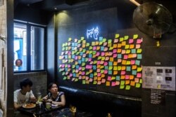 Customers sit near blank notes on a “Lennon Wall” inside a pro-democracy restaurant in Hong Kong on July 3, 2020, in response to a new national security law introduced in the city.