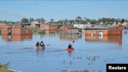 People row kayaks on flooded streets in the city of Bahia Blanca, in the province of Buenos Aires, Argentina, March 9, 2025. 