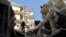 A man stands on a destroyed building after what activists said was an air raid by forces loyal to Syrian President Bashar Al-Assad, in Aleppo's district of Al Sukari Dec. 24, 2013.