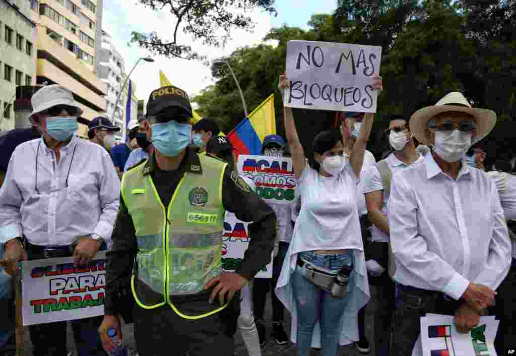 Una mujer sostiene un cartel que dice en espa&#241;ol &quot;No m&#225;s bloqueos&quot; durante la marcha silenciosa para apoyar el desbloqueo de la ciudad.