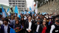 El presidente electo Bernardo Arévalo, en el centro, encabeza una marcha en protesta por la interferencia judicial en las elecciones que ganó en agosto en la Ciudad de Guatemala, el jueves 7 de diciembre de 2023. Arévalo asumirá el cargo el 14 de enero de 2024. 