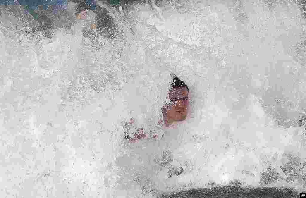 Australia&#39;s rugby player Kane Douglas plays bodysurfs during a warm down session at Coogee Beach in Sydney, Australia.