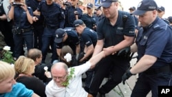 Polish police remove protesters staging an anti-government demonstration in Warsaw, Poland,, June 10, 2017. The demonstrators attempted to block a group led by Jaroslaw Kaczynski, leader of the ruling conservative Law and Justice party, commemorating the 2010 plane crash that killed his twin brother and 95 others. 