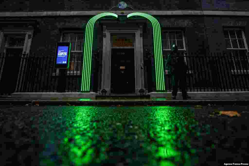 A green arch is lit over the door of number 10 Downing Street in London on Oct. 29, 2021 in preparation for the COP26 summit which will be taking place in Glasgow.