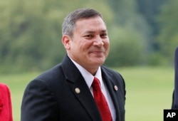 FILE - Guam Gov. Eddie Calvo is pictured at Buckingham Palace in London for a reception prior to the London Olympics, July 27, 2012.