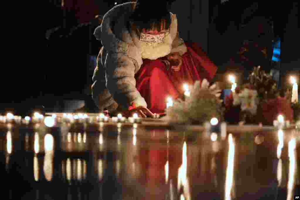 A girl lights candles at the site after the &quot;Goddess of Democracy&quot; statue, a memorial for those killed in the 1989 Tiananmen crackdown, was removed from the Chinese University of Hong Kong.