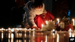 FILE — A girl lights candles Dec. 23, 2021, after a memorial for those killed in the 1989 Tiananmen crackdown was removed from the Chinese University of Hong Kong. A professor who created seminar about Tiananmen was fired after she was denied a renewal of her work visa.  