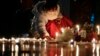 FILE — A girl lights candles Dec. 23, 2021, after a memorial for those killed in the 1989 Tiananmen crackdown was removed from the Chinese University of Hong Kong. A professor who created seminar about Tiananmen was fired after she was denied a renewal of her work visa.  