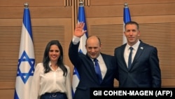 Le nouveau Premier ministre israélien Naftali Bennett (au centre), avec les membres de la Knesset Ayelet Shaked (à g.) et Matan Kahana après une session spéciale pour voter sur un nouveau gouvernement à la Knesset à Jérusalem, le 13 juin 2021.