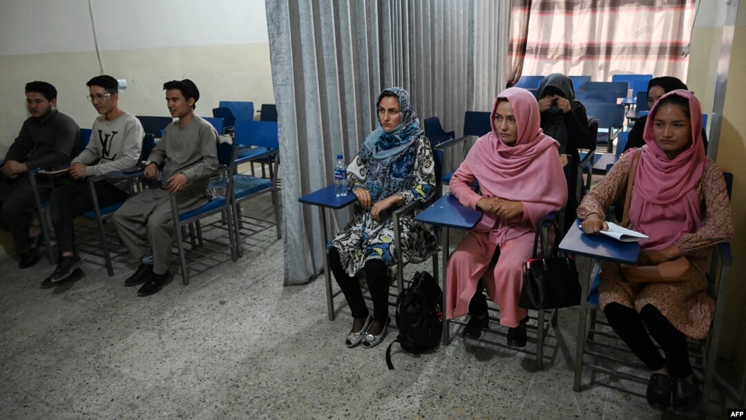 Students attend a class bifurcated by a curtain separating males and females at a private university in Kabul, Afghanistan, Sept. 7, 2021, to follow the Taliban's ruling.