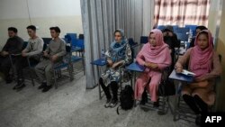 Students attend a class bifurcated by a curtain separating males and females at a private university in Kabul, Afghanistan, Sept. 7, 2021, to follow the Taliban's ruling.