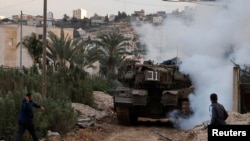 Seorang pria bersiap untuk melempari tank Israel yang beroperasi di wilayah Jenin, Tepi Barat, pada 23 Februari 2025. (Foto: Reuters/raneen Sawafta)