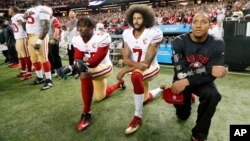 Colin Kaepernick (numéro 7) et Eli Harold (58) des San Francisco 49ers s'agenouillent lors de l'hymne national avant le match contre les Falcons à Atlanta le 18 décembre 2016.