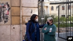 Matteo Coccimiglio (kanan), berbincang dengan Sonia Mugello, seorang guru di Sekolah Seni Ripetta di Roma, Italia, 24 Maret 2021. (AP Photo/Alessandra Tarantino)
