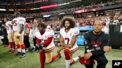 FILE - Francisco 49ers quarterback Colin Kaepernick (7) and outside linebacker Eli Harold (58) kneel during the playing of the national anthem before an NFL football game against the Atlanta Falcons in Atlanta, Dec. 18, 2016,. 