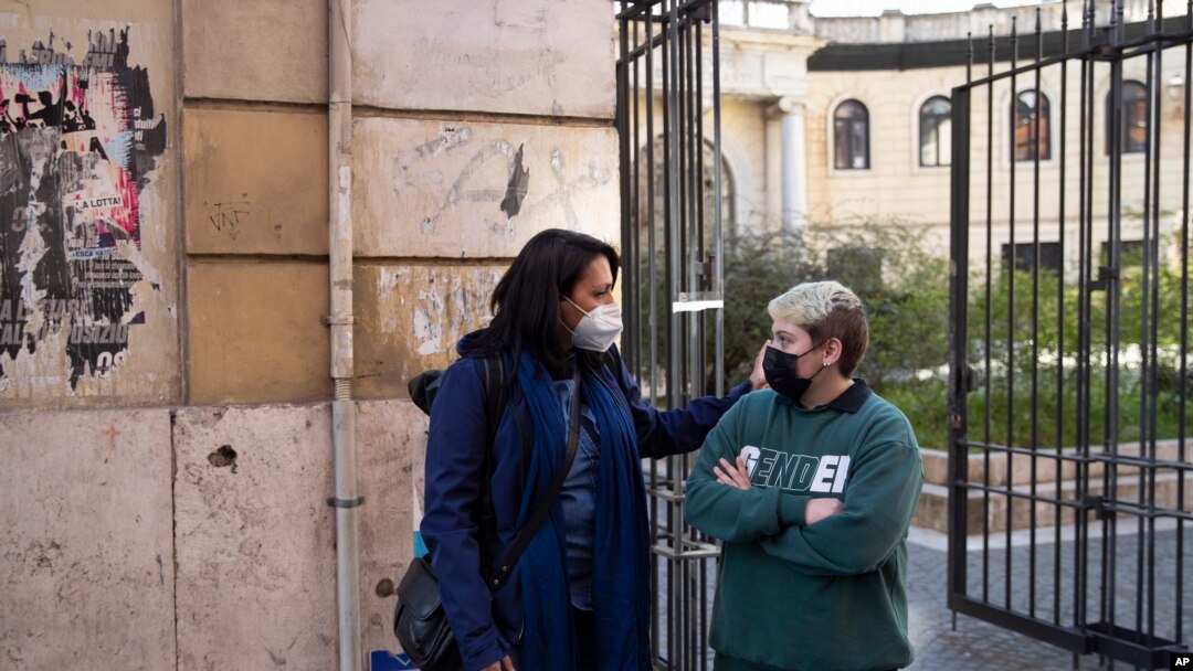 Matteo Coccimiglio (kanan), berbincang dengan Sonia Mugello, seorang guru di Sekolah Seni Ripetta di Roma, Italia, 24 Maret 2021. (AP Photo/Alessandra Tarantino)
