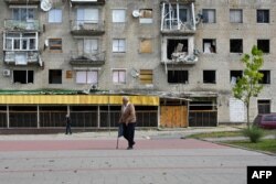 FILE - A man walks past a residential building destroyed as a result of hostilities in 2022 in the town of Izyum, Kharkiv region, on September 10, 2023, during the first anniversary of liberation of the small town in eastern Ukraine.