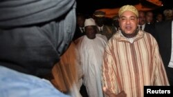 King Mohammed (R) of Morocco greets an unidentified person as he is welcomed by Mali's new President Ibrahim Boubacar Keita (C) at the Bamako-Senou International Airport September 18, 2013. REUTERS/Thierry Gouegnon (MALI - Tags: POLITICS ROYALS) - RTX13QN