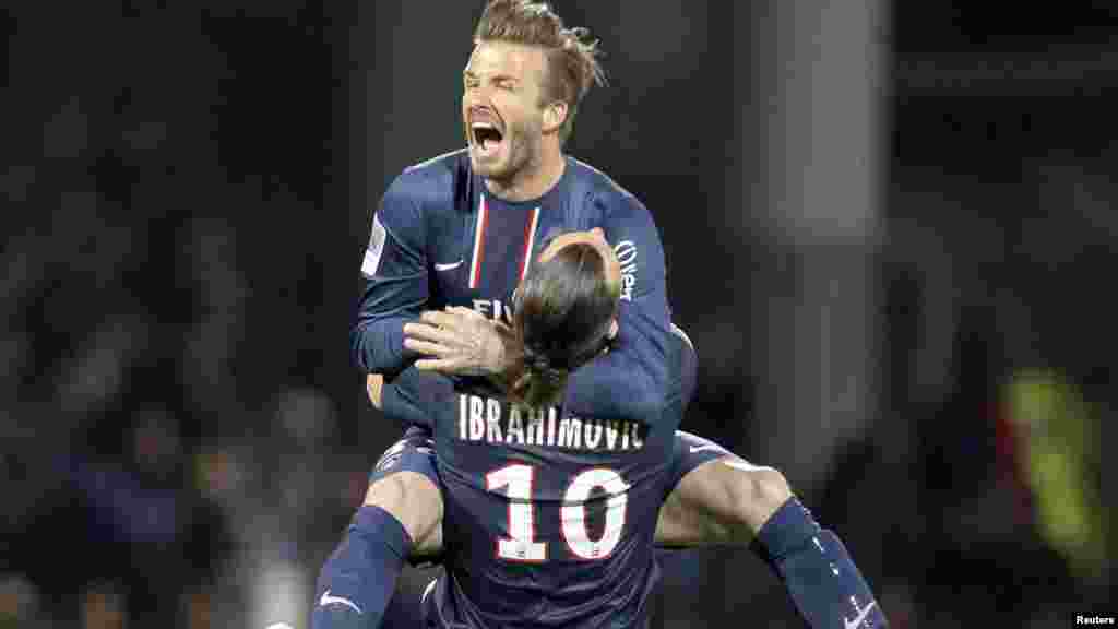 Paris Saint-Germain's Zlatan Ibrahimovic and David Beckham celebrate at the end of their team's French Ligue 1 soccer match against Olympique Lyon in Lyon May 12, 2013.