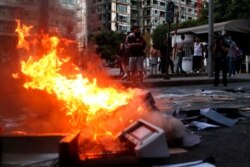 Anti-government protesters set fire to documents they confiscated from the ministry of economy during a protest marking the first anniversary of the massive blast at Beirut's port, near Parliament Square, In Beirut, Lebanon, Aug. 4, 2021.