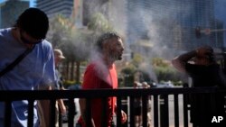 Personas se refrescan en rociadores de agua en el Strip de Las Vegas, el domingo 7 de julio de 2024 en Las Vegas, mientras el calor persiste en la región con temperaturas potencialmente mortales.