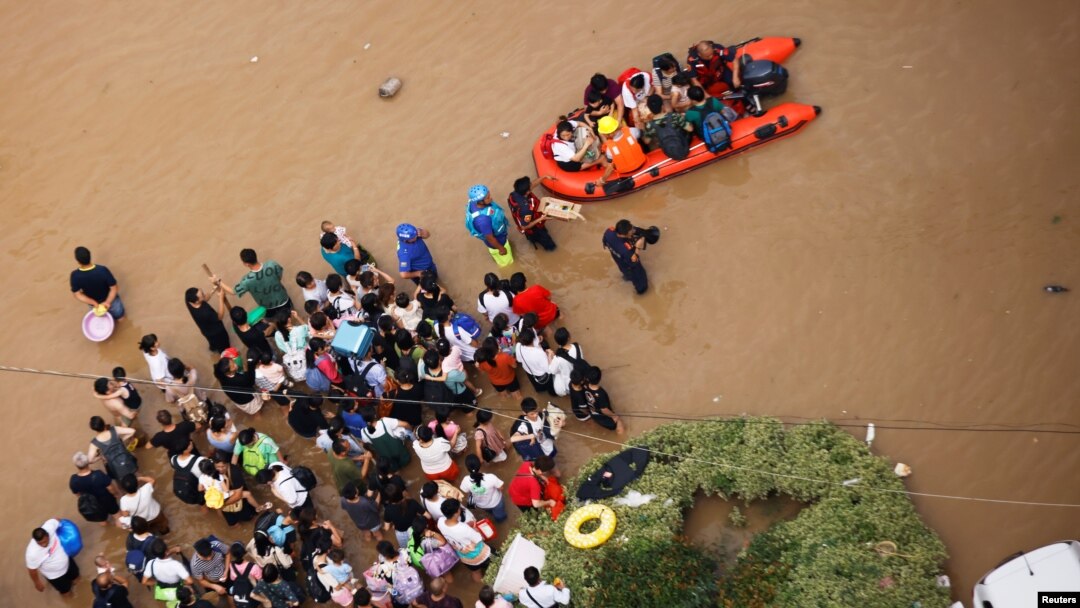Warga yang terdampak banjir di Zhengzhou, provinsi Henan, China, menunggu untuk dievakuasi, 22 Juli 2021. (REUTERS/Aly Song)
