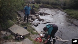 FILE - Elden Kinderknetch was looking for gold near Atlantic City, Wyoming on Sept. 13, 1998. The stepping stones made it easier to cross the creek. (AP File Photo)