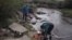 FILE - Elden Kinderknetch was looking for gold near Atlantic City, Wyoming on Sept. 13, 1998. The stepping stones made it easier to cross the creek. (AP File Photo)