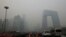 FILE - Cars travel on a road amid heavy haze in Beijing, Feb. 21, 2014. 