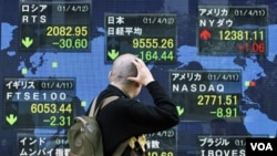 Seorang pria di Tokyo mengamati turunnya indeks-indeks saham dunia (foto: dok).