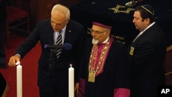 Turkey's Chief Rabbi Izak Haleva (C) and Istanbul Governor Huseyin Avni Mutlu (L) light candles, in memory of holocaust victims, during a commemoration to mark International Holocaust Remembrance Day at Neve Shalom Synagogue in Istanbul, January 26, 2012.
