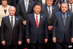 Chinese President Xi Jinping (center) stands with Russian President Vladimir Putin (left) Turkish President Recep Tayyip Erdogan (right) and other leaders to pose for a group photo before the opening ceremony of the Belt and Road Forum.